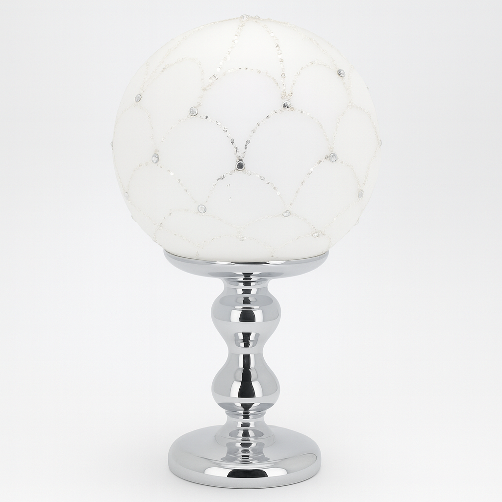 Lume decorativo Bagutta con sfera bianca decorata con strass e base argentata.